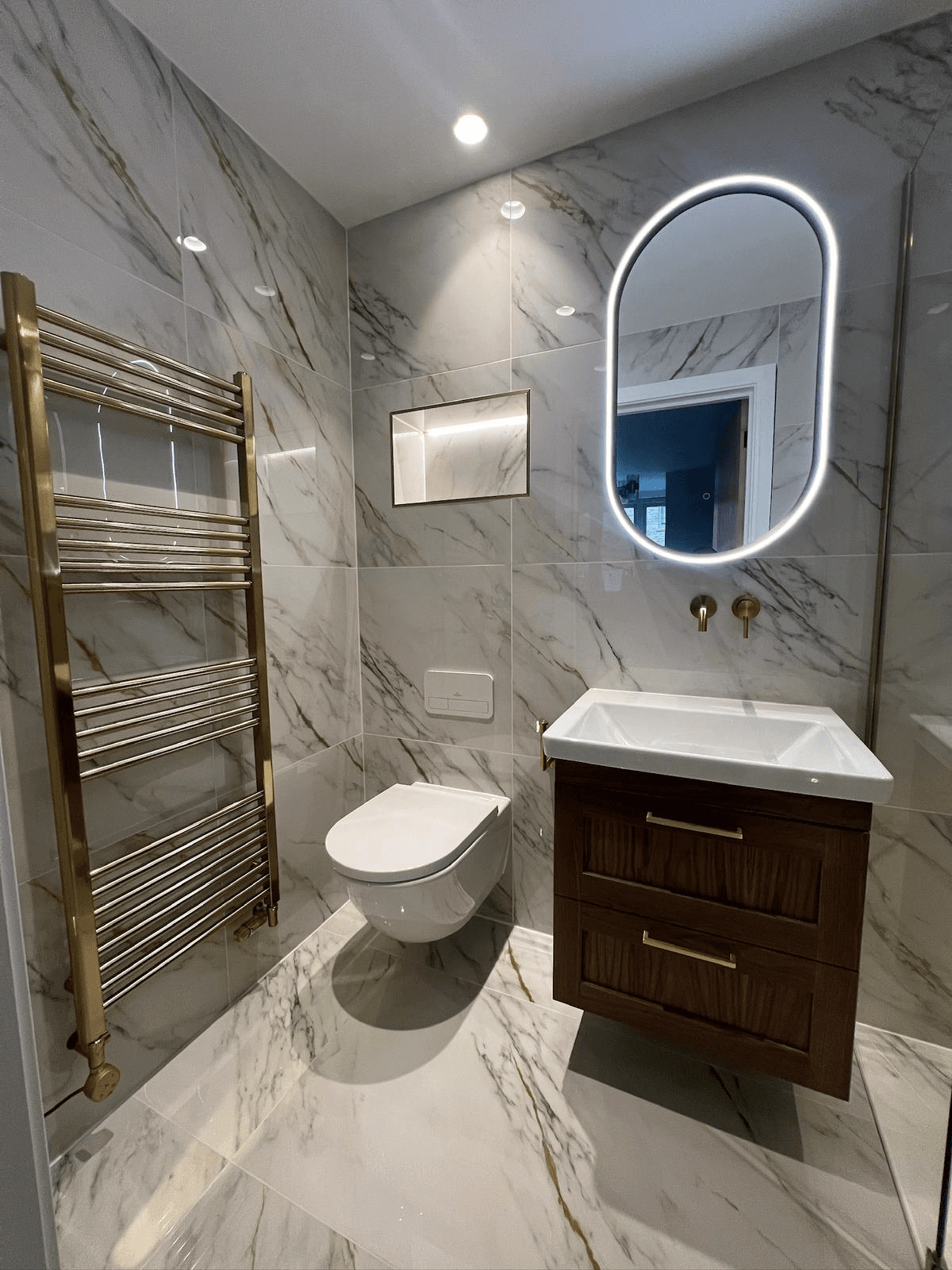 Luxurious marble bathroom with gold heated towel rail